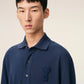 Navy blue polo shirt with a small logo on a beige background ami paris