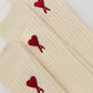 Beige sock with a red heart logo on a white background