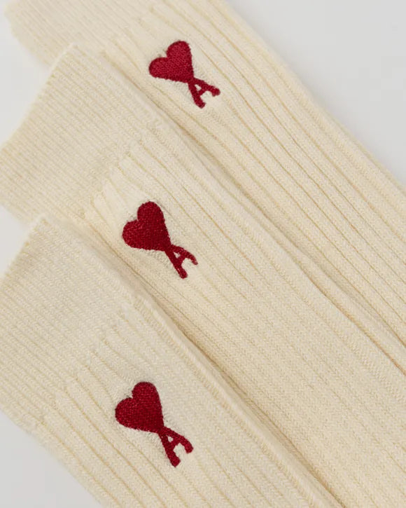 Beige sock with a red heart logo on a white background
