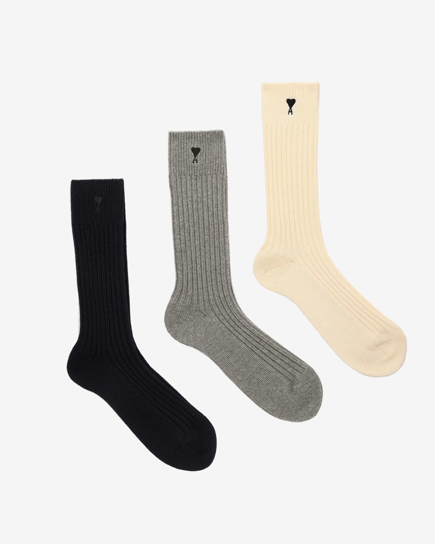 Three pairs of socks in beige, gray, and black on a light beige background