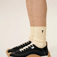 Three pairs of socks in beige, gray, and black on a light beige background