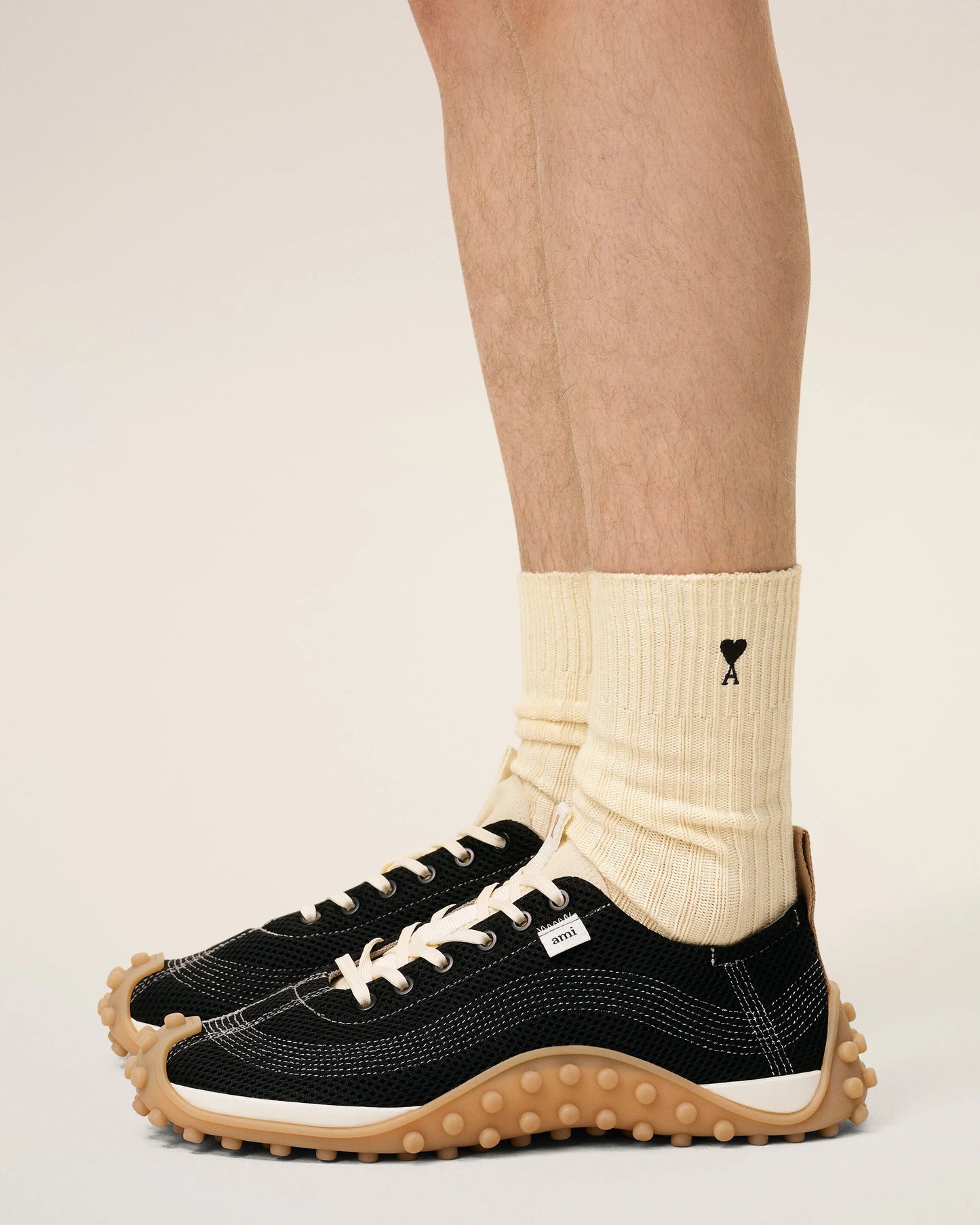 Three pairs of socks in beige, gray, and black on a light beige background