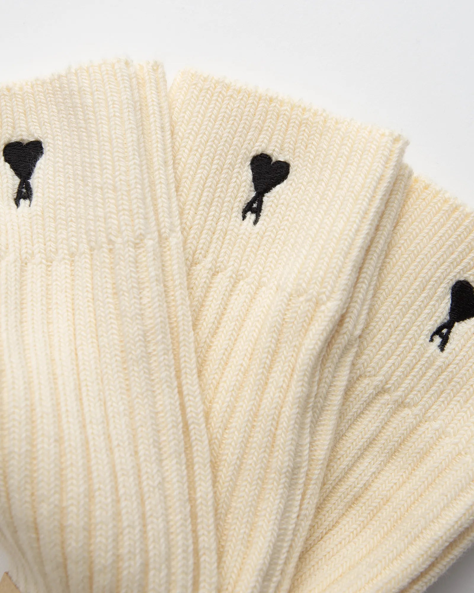 Pair of cream socks with a visible brand label on a light gray background