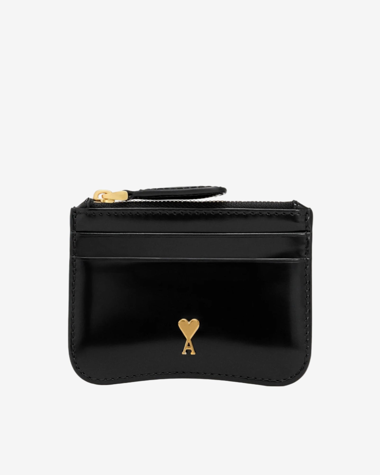 Black wallet with gold heart emblem on a beige background