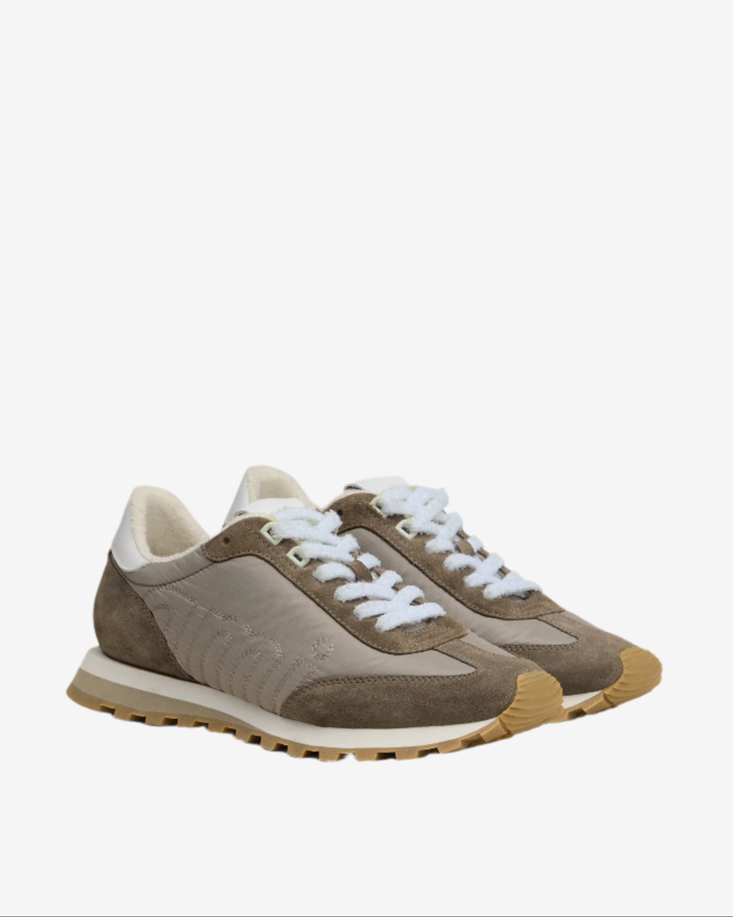 Pair of brown sneakers with white laces on a beige background