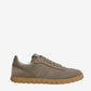 Beige sneaker with brown sole on a light beige background