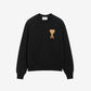 Black sweatshirt with a gold heart design on a beige background
