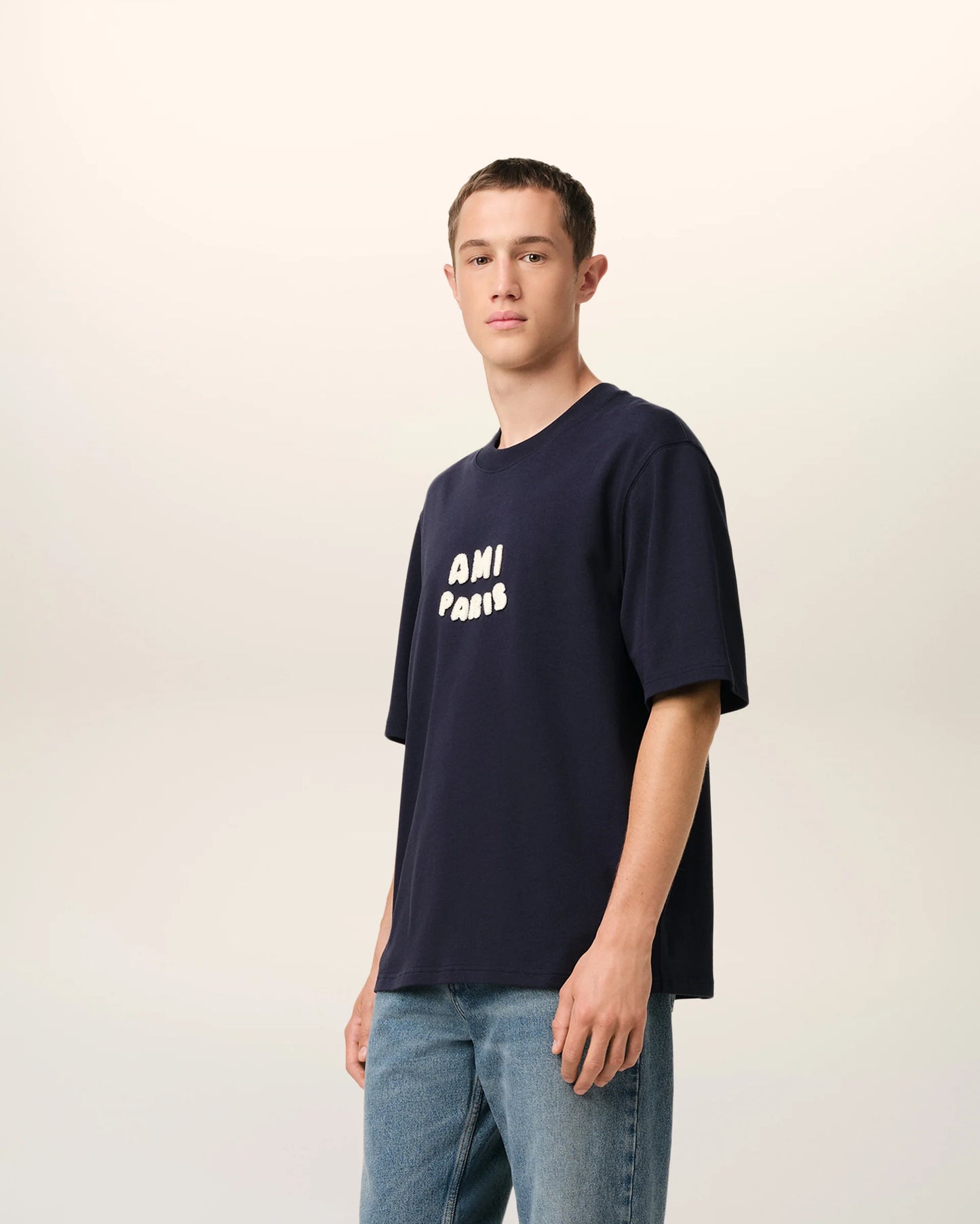 Navy blue t-shirt with 'AMI PARIS' text on a light gray background