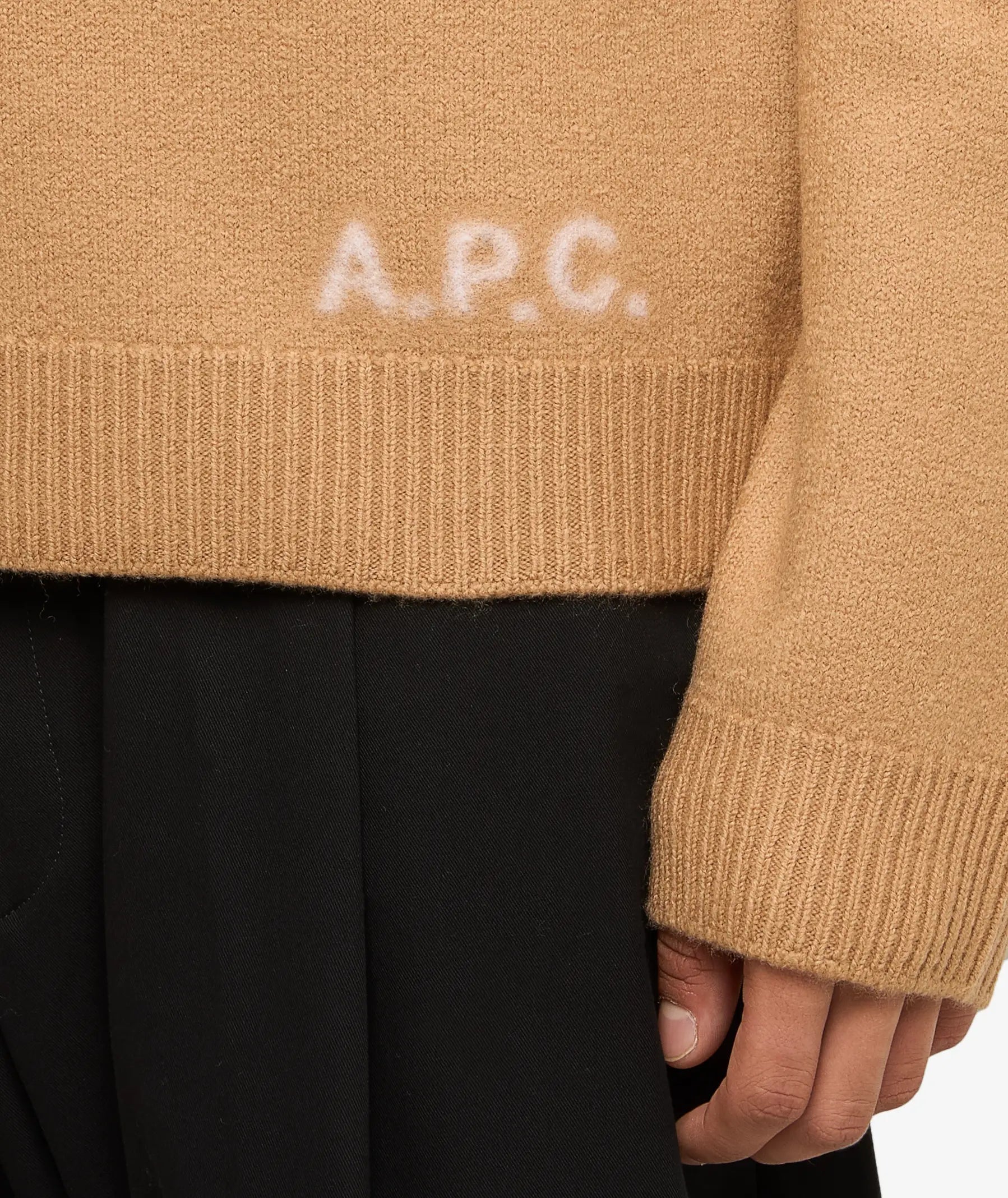 Beige sweater with 'A.P.C.' branding on a light gray background