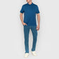 Person wearing a blue polo shirt and jeans on a plain background