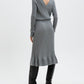 Woman wearing a gray ribbed dress with a V-neckline on a white background