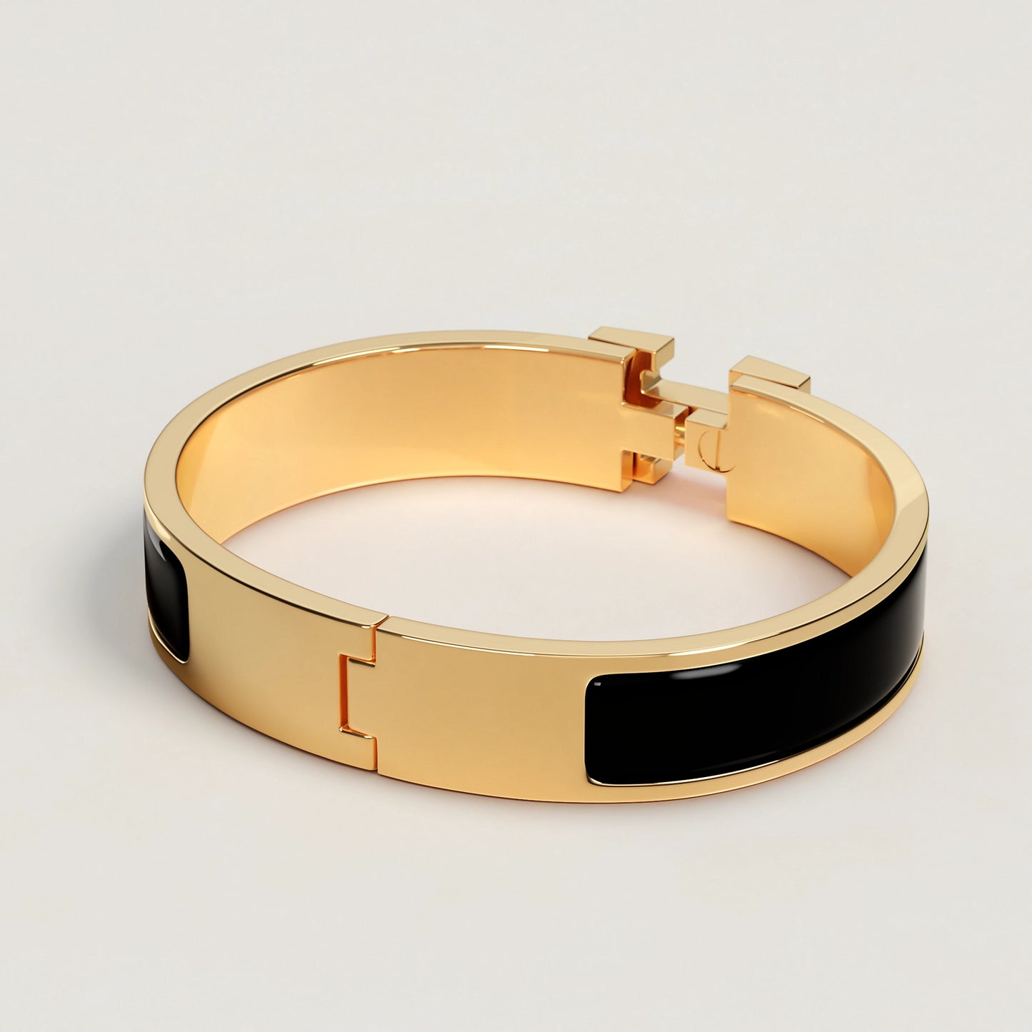 Gold bracelet with black band on a light gray background