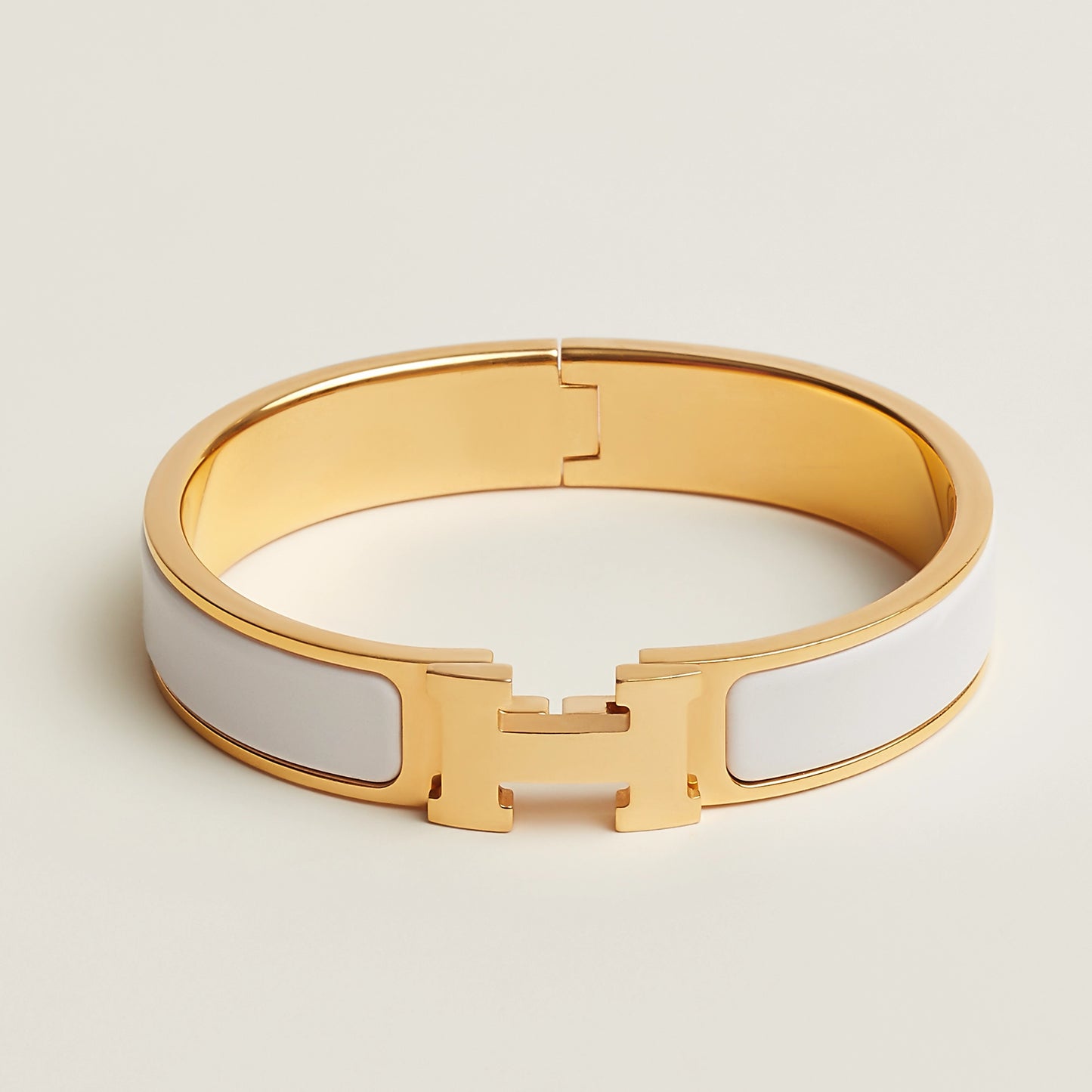 Gold and white bracelet on a light beige background