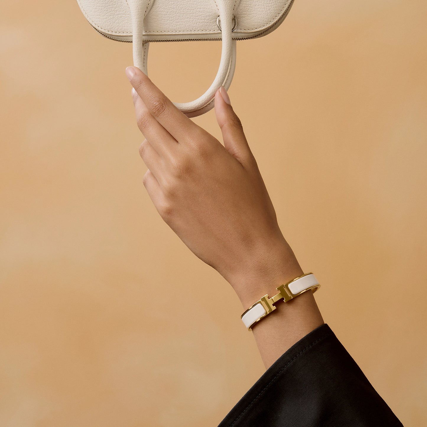Gold and white bracelet on a light beige background