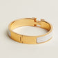 Gold and white bracelet on a light beige background