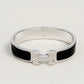 Silver bracelet with black accents on a light gray background