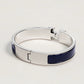 Silver bracelet with blue accents on a light gray background