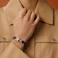 Silver bracelet with blue accents on a light gray background