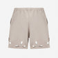 Beige shorts with cut-out designs on a white background
