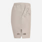 Beige shorts with cut-out designs on a white background