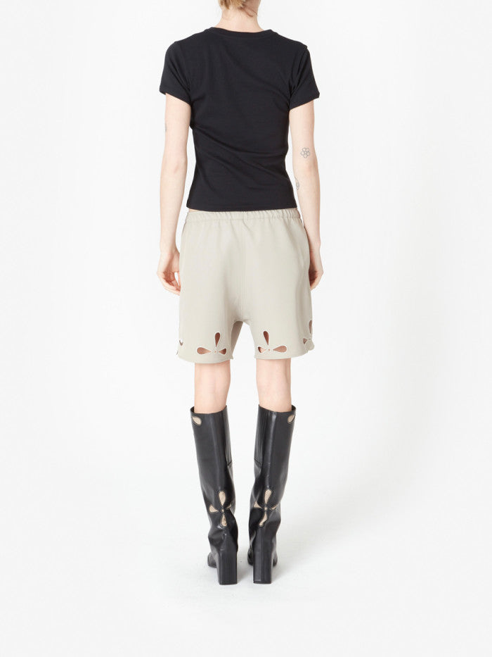 Beige shorts with cut-out designs on a white background