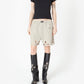 Beige shorts with cut-out designs on a white background