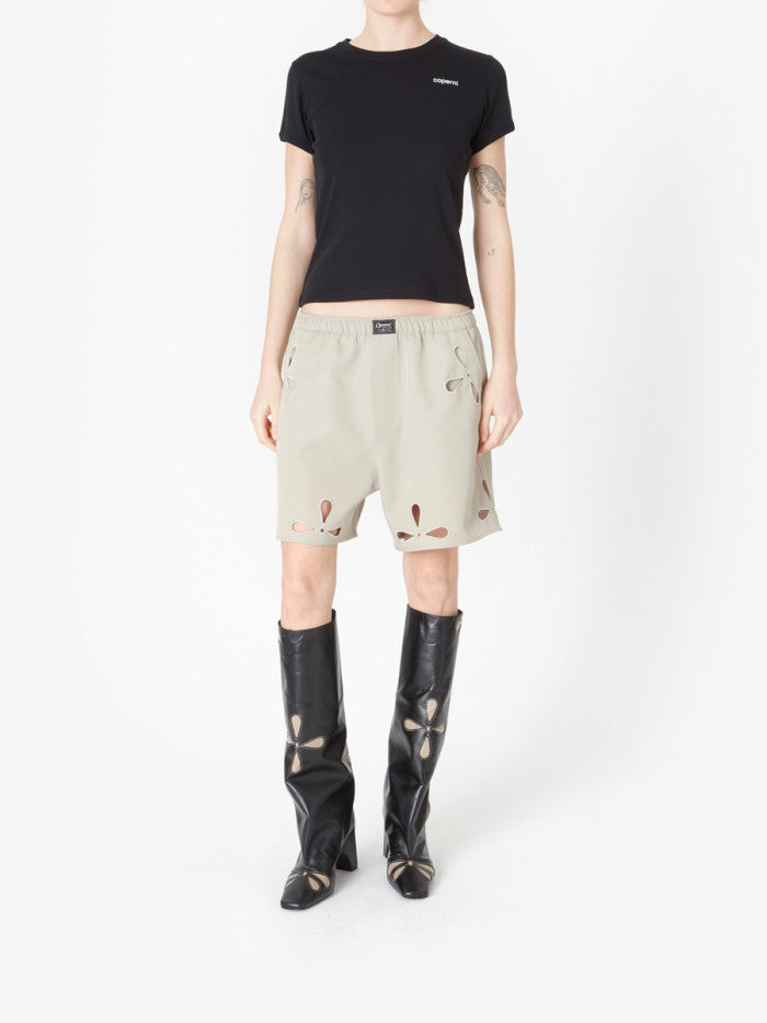 Beige shorts with cut-out designs on a white background