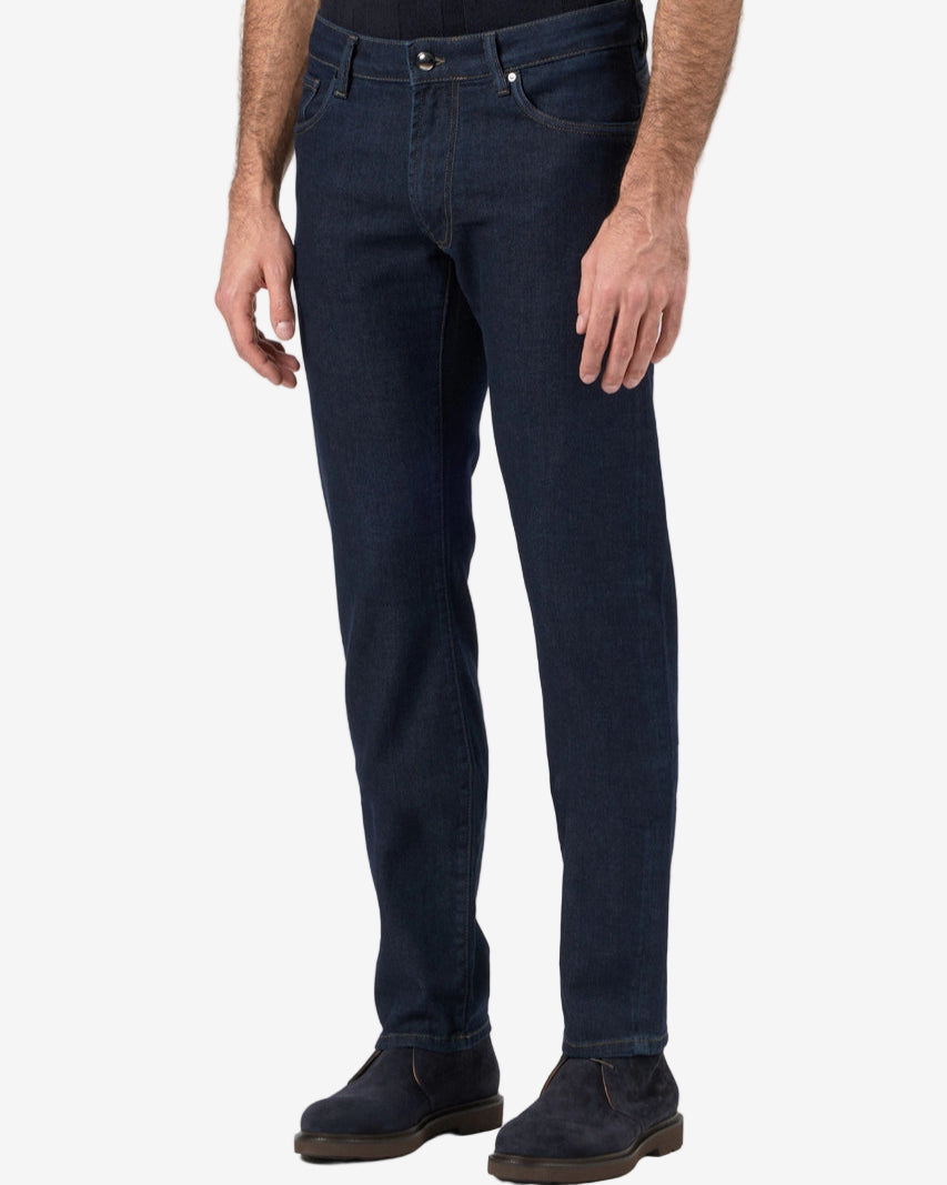 Person wearing dark blue jeans on a white background
