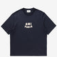 Navy blue t-shirt with 'AMI PARIS' text on a light gray background