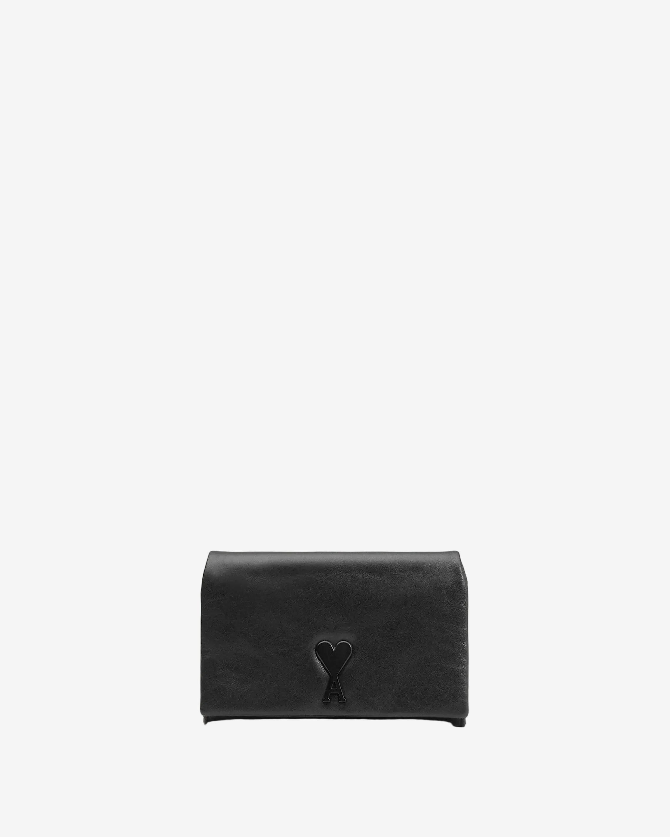 Person holding a black handbag against a neutral background