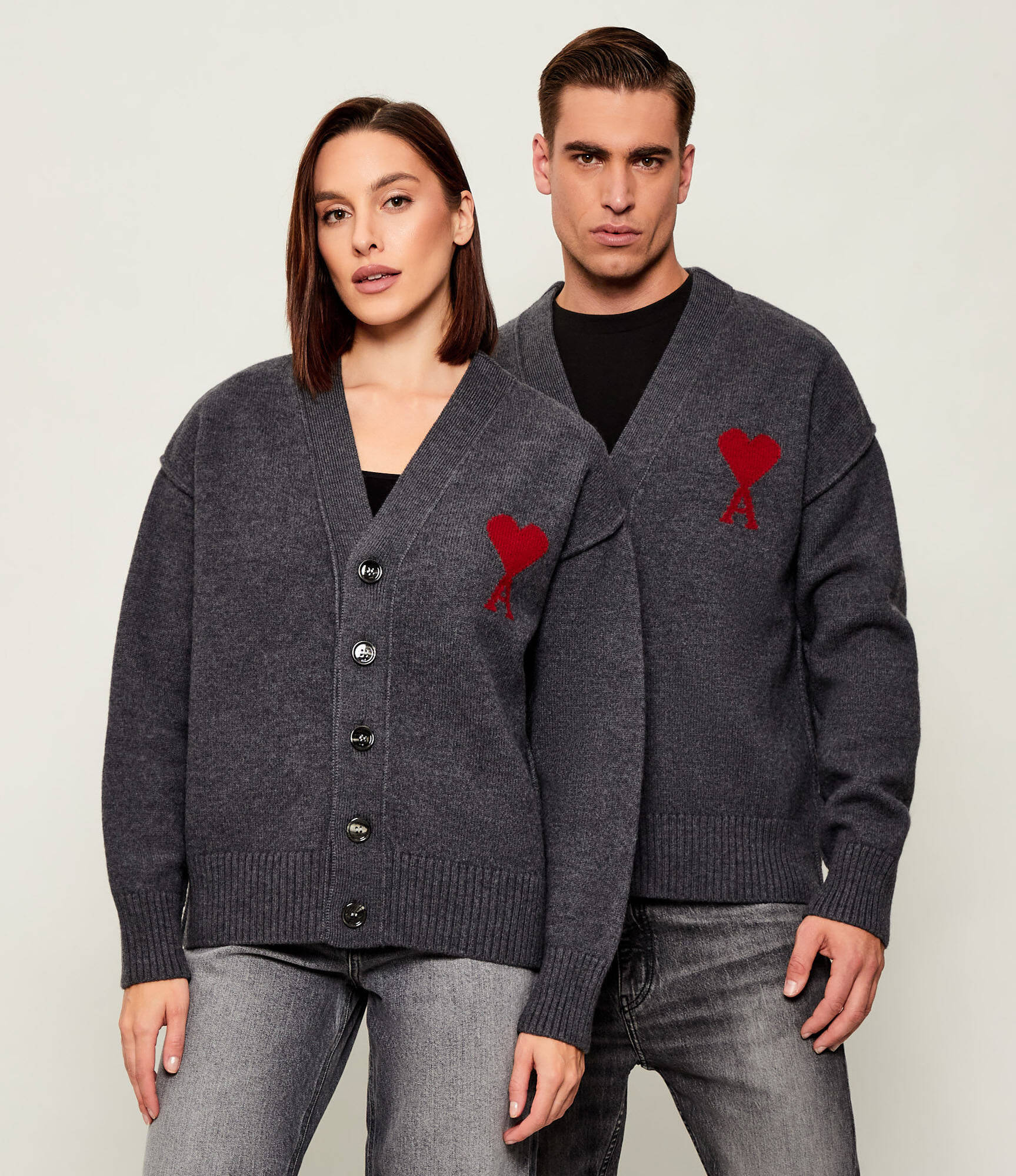 Dark gray cardigan with a red heart emblem on a beige background ami paris