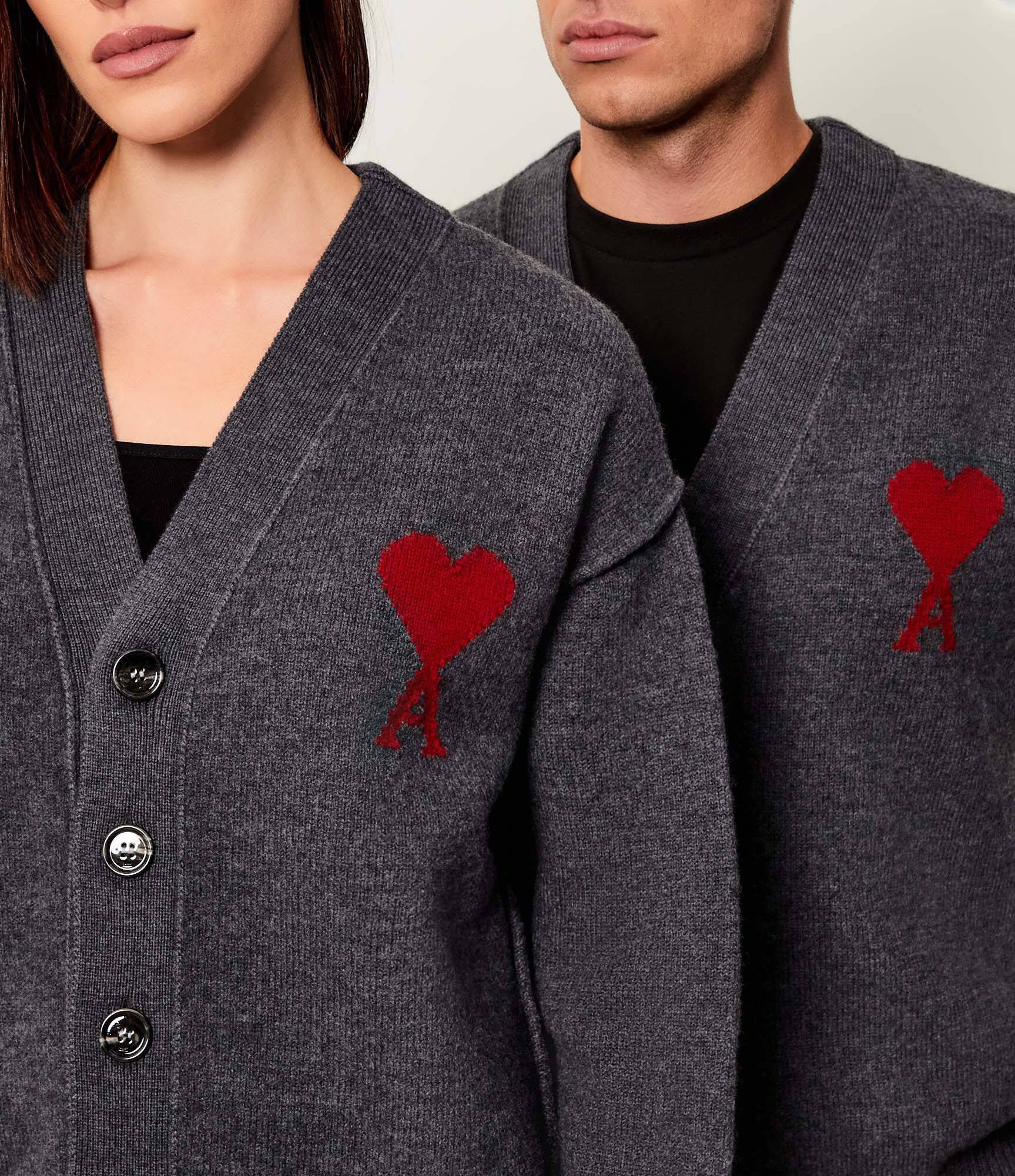 Dark gray cardigan with a red heart emblem on a beige background ami paris