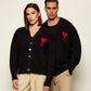 Black cardigan with a red heart emblem on a beige background ami paris