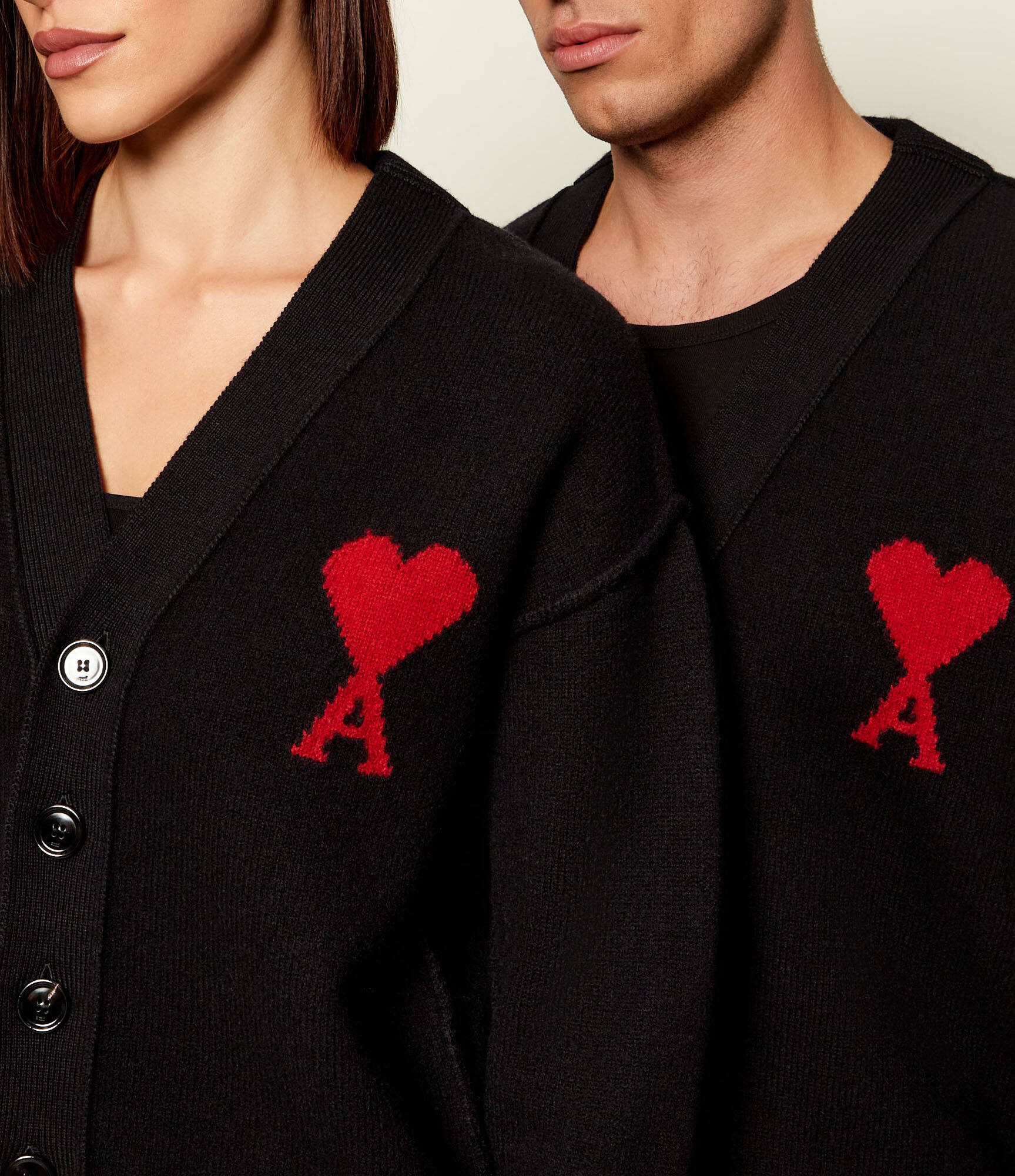 Black cardigan with a red heart emblem on a beige background ami paris