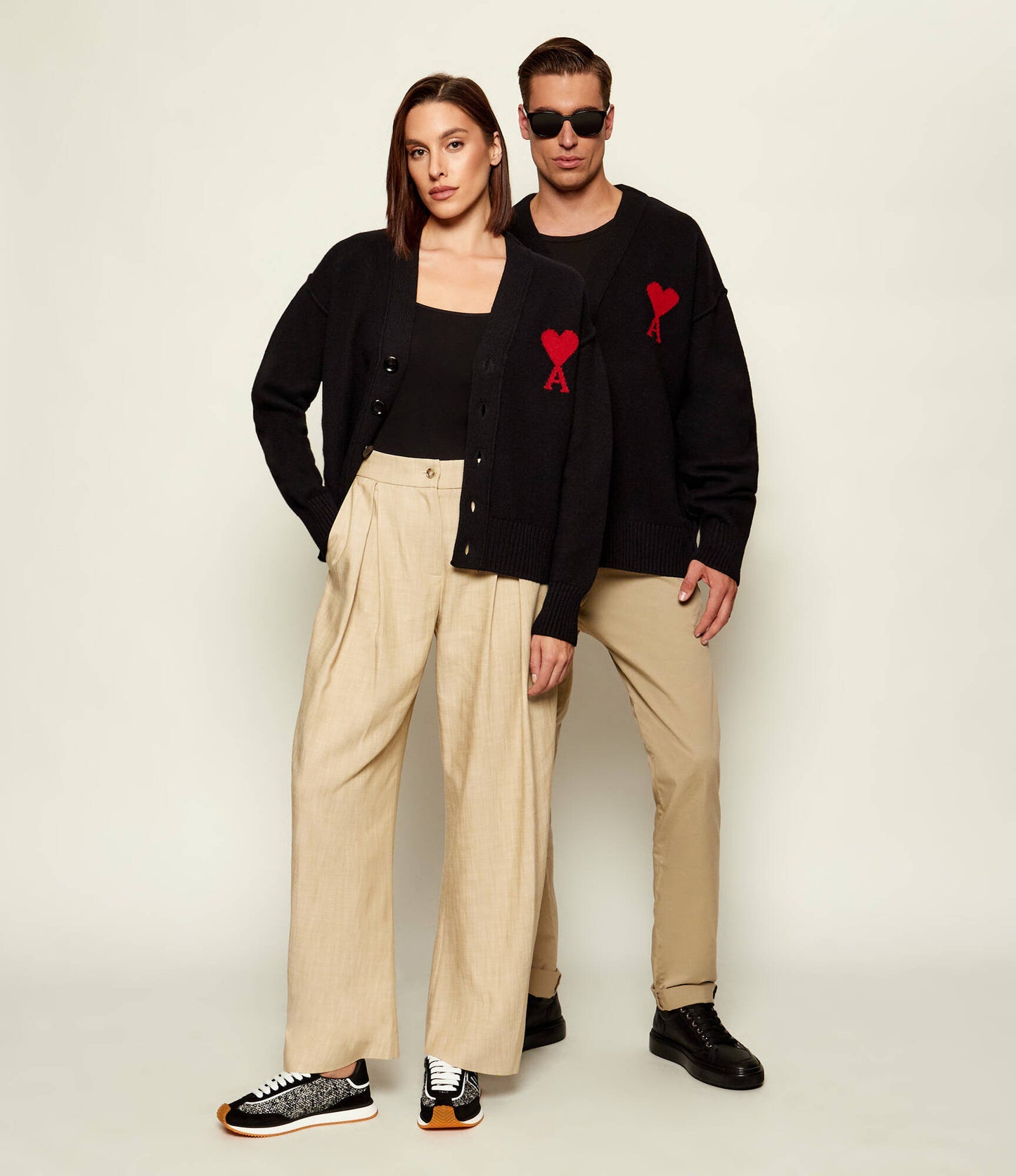 Black cardigan with a red heart emblem on a beige background ami paris