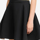 Black skirt worn by a person on a neutral background