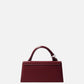 Red handbag with a visible brand logo on a light gray background