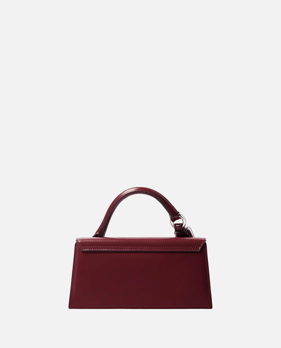 Red handbag with a visible brand logo on a light gray background