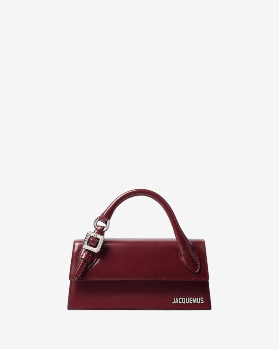 Red handbag with a visible brand logo on a light gray background