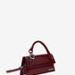 Red handbag with a visible brand logo on a light gray background