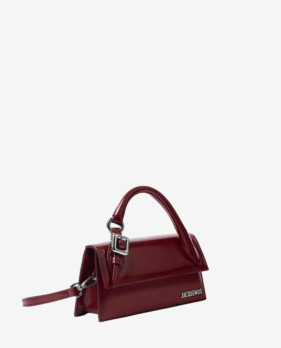 Red handbag with a visible brand logo on a light gray background