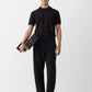 Black polo shirt with a monogram on a white background