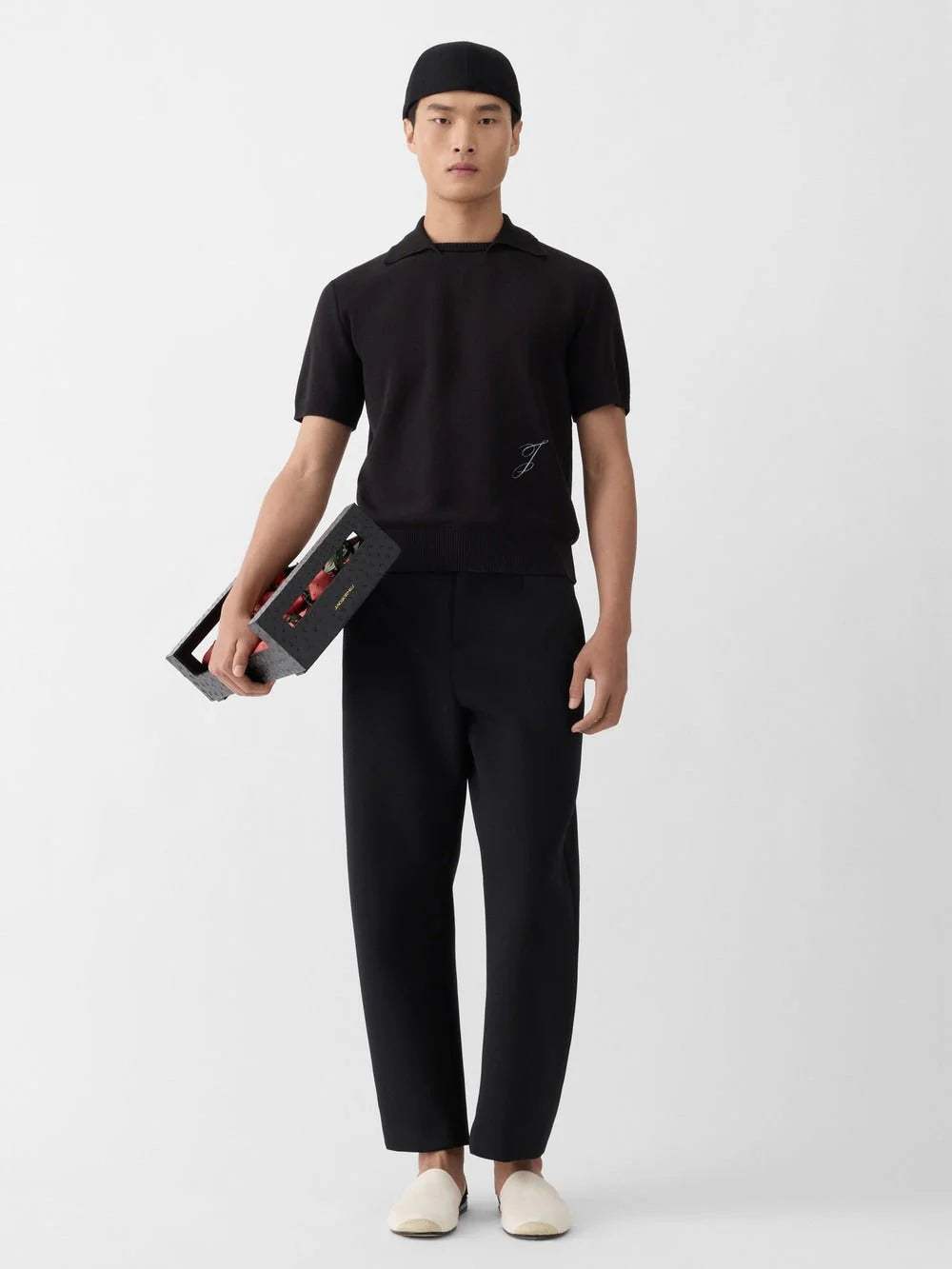 Black polo shirt with a monogram on a white background