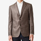 Man wearing a brown blazer over a white shirt on a light gray background