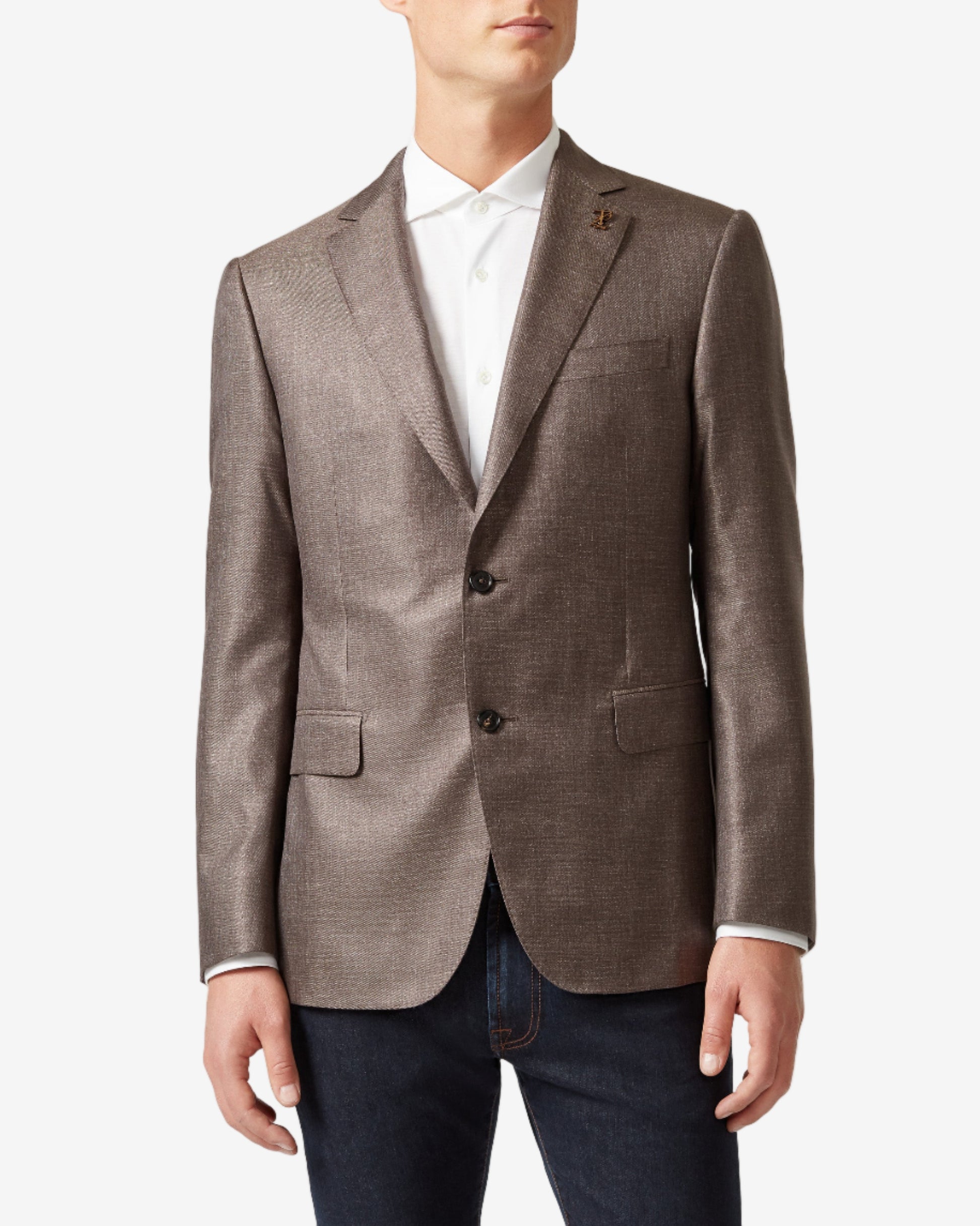 Man wearing a brown blazer over a white shirt on a light gray background