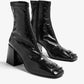 Black patent leather tabi boots on a white background