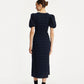 Woman wearing a dark blue dress with puff sleeves on a white background