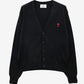Black cardigan with a small red heart emblem on a white background