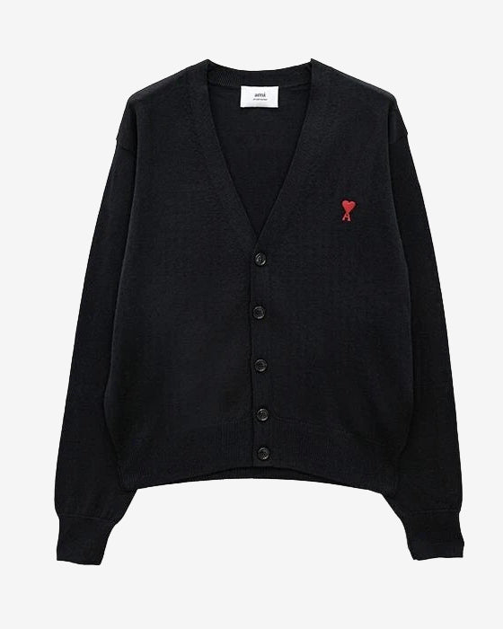 Black cardigan with a small red heart emblem on a white background