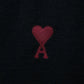 Black cardigan with a small red heart emblem on a white background